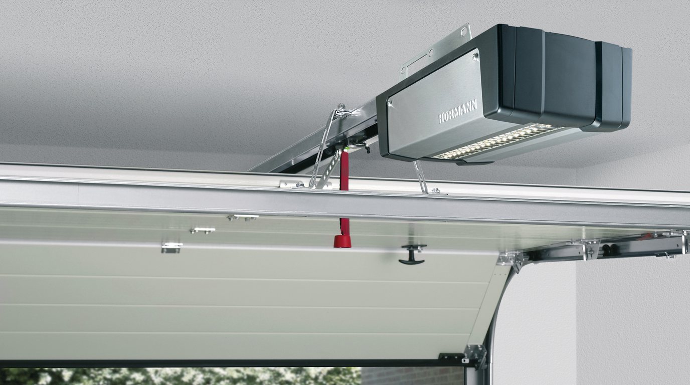 Garage mit Torantrieb an der Decke und halb geöffnetem Sektionaltor