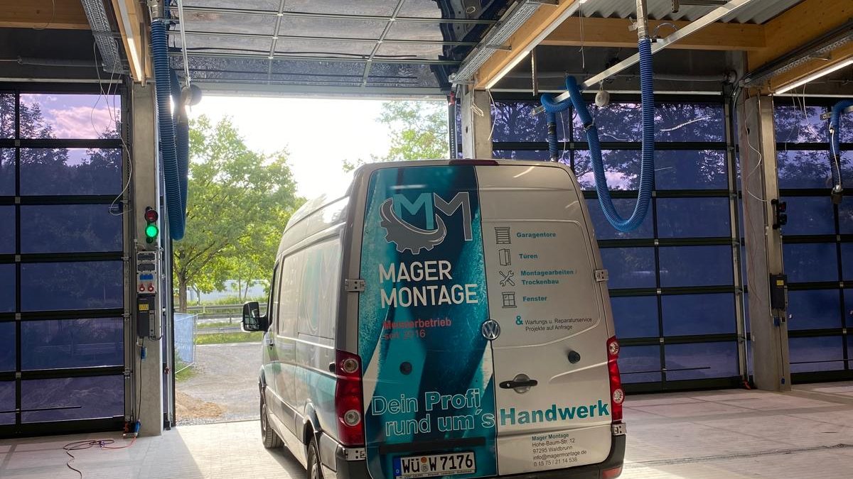 Firmenwagen von Mager Montage in einer Halle mit verglasten Toren