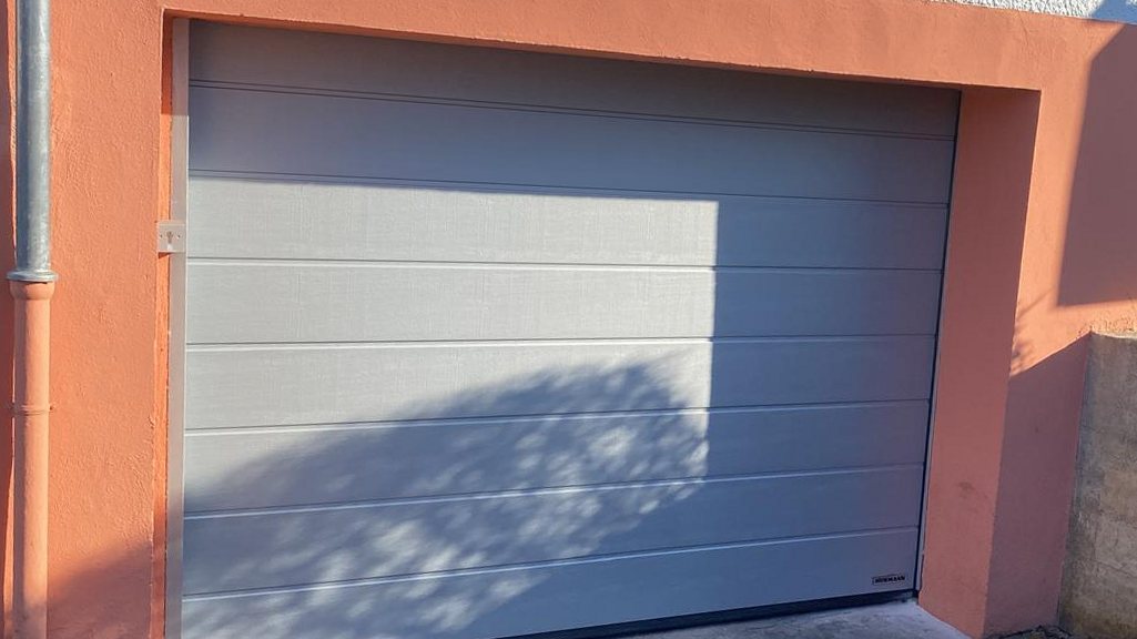 Neues Sektional-Garagentor an einem Wohnhaus