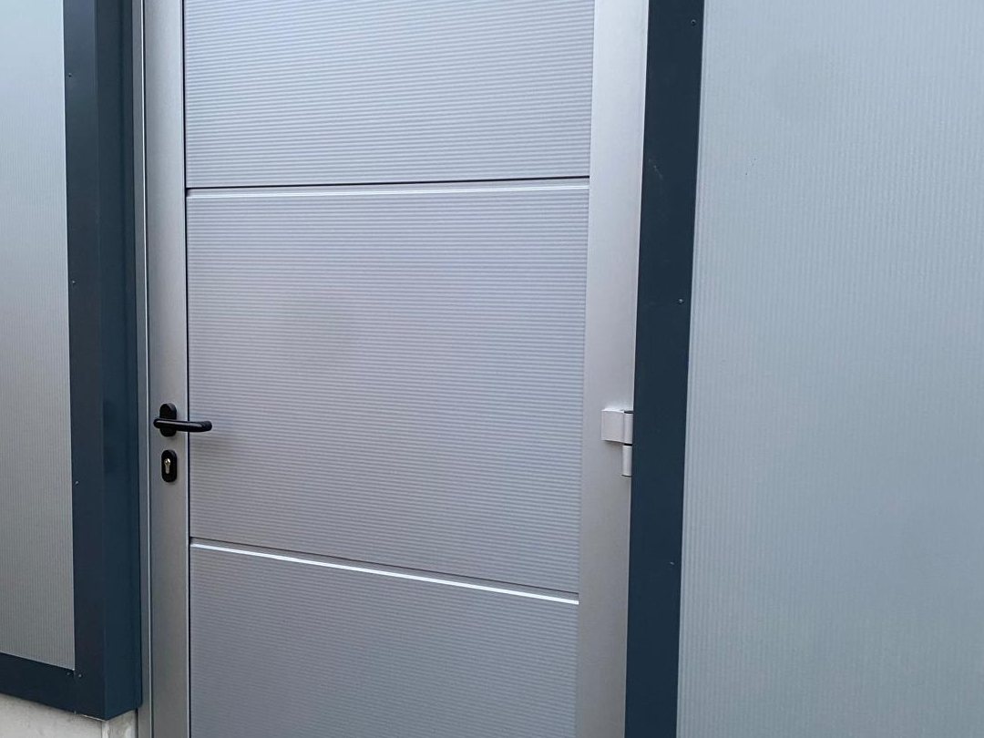 Nebeneingangstür in einer Hallenfassade
