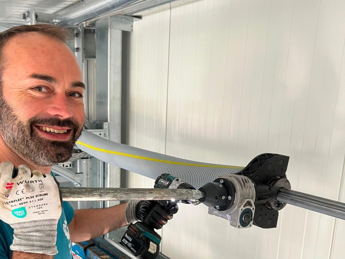Benjamin Mager montiert auf der Hubarbeitsbühne den Antrieb einer Torwelle
